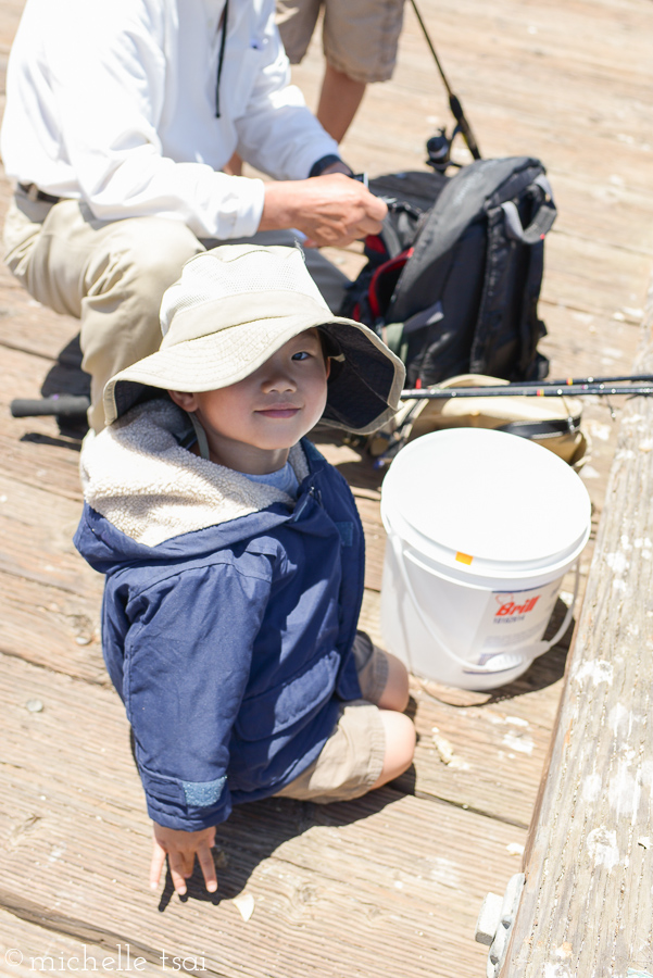 Waiting as Grandpa set up each of the fishing poles. In other news, I love kids in hats.