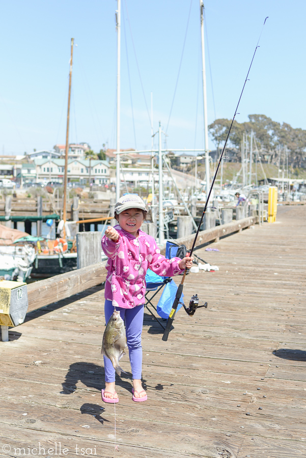 Little fisher girl caught a nice-sized fish.